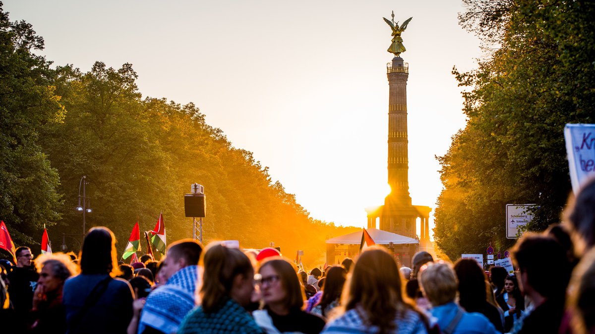 Vue de la colonne de la victoire à Berlin avec une foule de manifestants et des drapeaux palestiniens